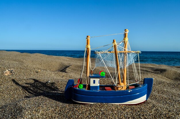 Spielzeugboot am Sandstrand