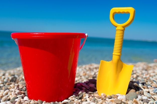 Spielzeugeimer und Spaten auf den Strandsteinen hautnah