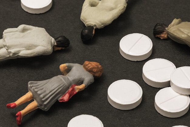 Spielzeugmänner aus Plastik und Pillen Konzept der Vergiftung von Menschen mit minderwertigen Drogen