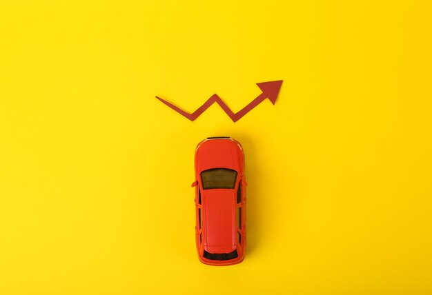 Foto spielzeugmodell autowachstumspfeil auf gelbem hintergrund