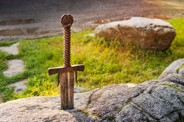 Foto spielzeugmodell excalibur, könig arthurs schwert im stein. blankwaffen vom legendären pro-könig arthur.