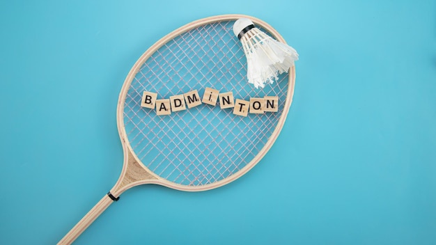 Foto spielzeugsteine auf dem blauen tisch mit wort badminton