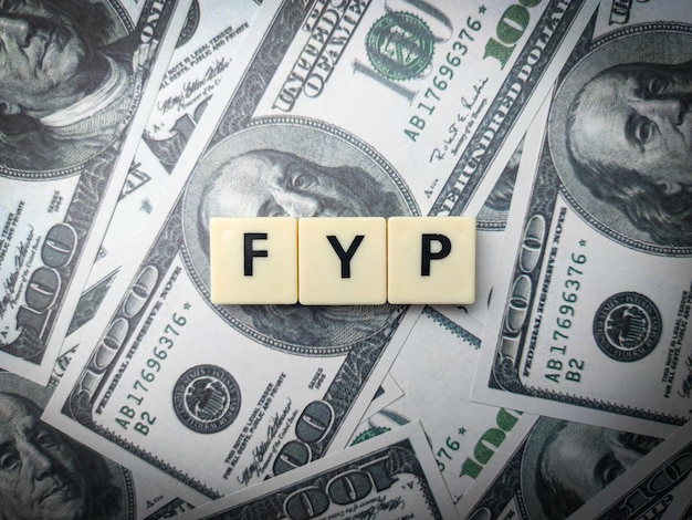 Spielzeugwort und -banknoten mit dem Wort FYP Busienss-Konzept