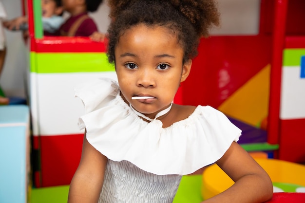 Spielzimmer Kindergarten Afroamerikanisches kleines Kind und verschiedene Freunde spielen und genießen die Zeit im Unterhaltungs- und Spielbereich für Kinder