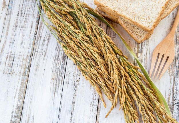 Spike und Vollkornbrot auf weißem Holztisch