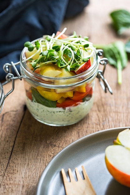 Foto spinat-apfel-pfeffer-tomaten-salat mit joghurt-kräuter-dressing im glas