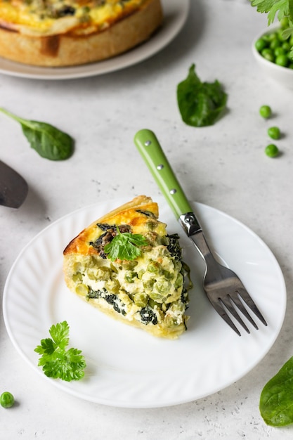 Spinat-Erbsen-Quiche, -Tarte oder -Torte mit Backzutaten.