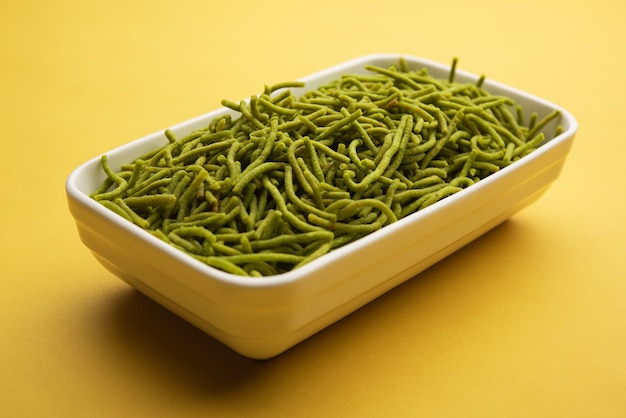 Spinat oder Palak Sev sind knusprig gebratene herzhafte Nudeln. Hausgemacht Dickes und dünnes grünes Shev oder Namkeen ist ein klassischer indischer Snack