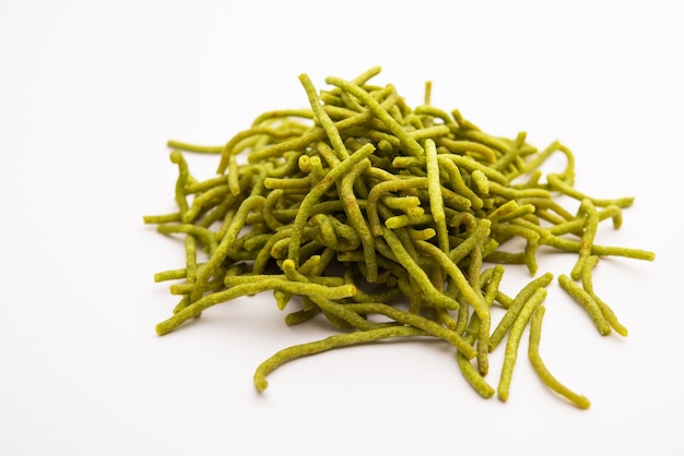 Spinat oder Palak Sev sind knusprig gebratene herzhafte Nudeln. Hausgemacht Dickes und dünnes grünes Shev oder Namkeen ist ein klassischer indischer Snack