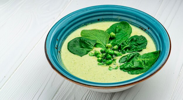 Foto spinatcremesuppe in schüssel auf weißem rustikalem tisch