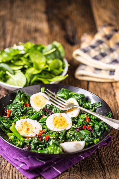 Spinatsalat. Frischer Spinatsalat mit Eier-Chili-Pfeffer und süßen Preiselbeeren.