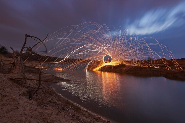 Foto spinnende drahtwolle am see gegen den himmel in der dämmerung