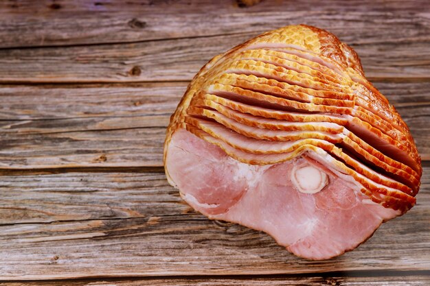 Spiral geschnittener Schweinefleischschinken auf Holzoberfläche