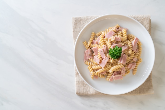 Spirali o salsa de crema de champiñones de pasta con jamón. Estilo de comida italiana