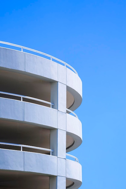 Spiralrampe des Parkhausgebäudes vor blauem Himmelshintergrund im vertikalen Rahmen