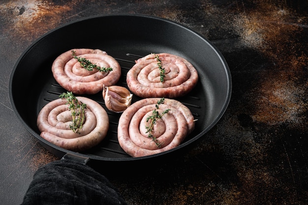 Spiralwurst aus Schweinefleisch in gusseiserner Pfanne auf altem dunklem Rustikal