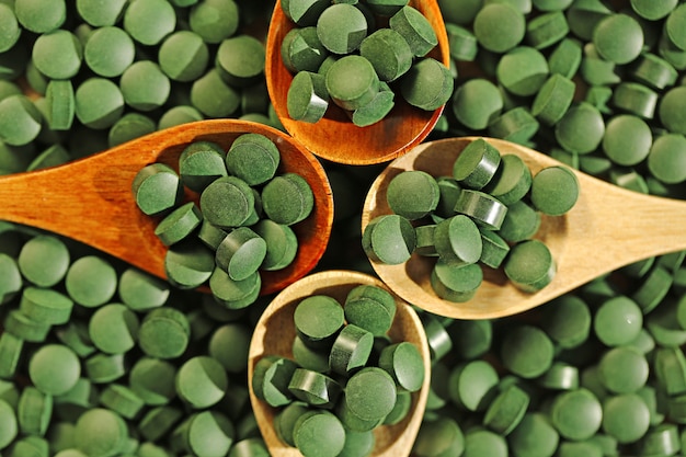 Spirulina. Pills Spirulina in vier Holzlöffeln. Superfood, Algen