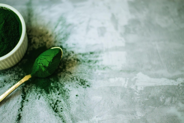 Spirulina-Pulver auf Betongrund verstreut