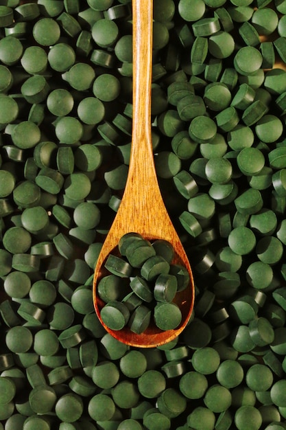 Spirulina-Tabletten in einem Löffel, Draufsicht