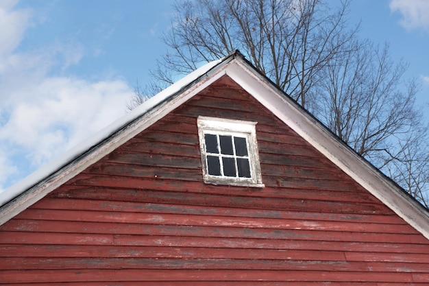 Spitze der alten roten amerikanischen traditionellen Scheune mit gealtertem Fenster