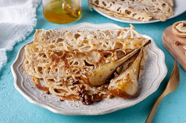 Spitzenpfannkuchen mit gebackenen Birnenwalnüssen auf dem Tisch in der Nähe