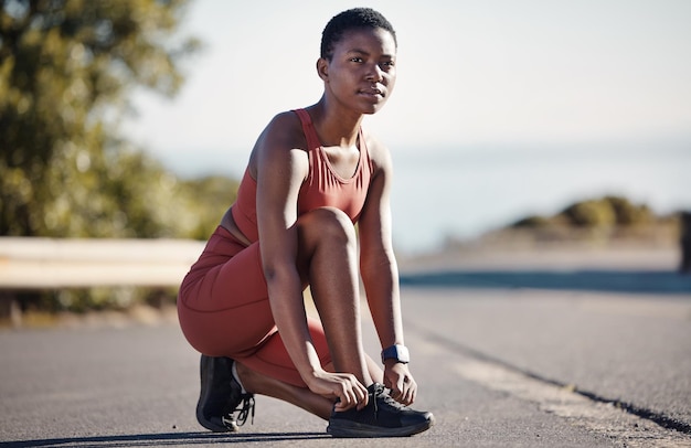 Spitzenschuhe Fitness und schwarze Frau Frau auf der Straße für Training, Laufen und Wellness in Nigeria Läufersportlerin und Mädchen binden Turnschuhe für Übungsfokus, Denkweise und Vision, Gesundheit und Ziele