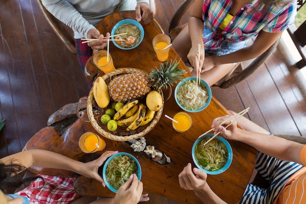 Spitzenwinkelsicht von den Leuten, die traditionelles Lebensmittel der asiatischen Nudelsuppe essen