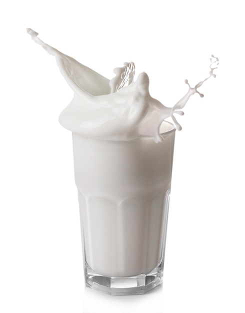 Splash de leche en vaso aislado en blanco