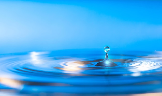 Foto splash water drop splashsplash das gotas caindo de gotas de água em um fundo azul