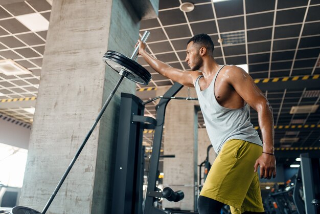 Sporsman haciendo ejercicio con barra en el gimnasio