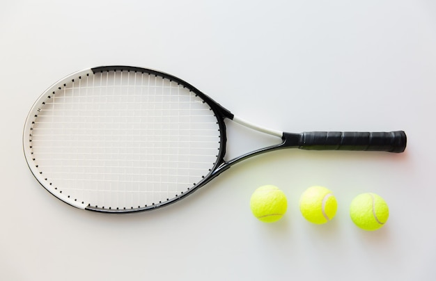 Sport, Fitness, gesunder Lebensstil und Objektkonzept - Nahaufnahme eines Tennisschlägers mit Bällen
