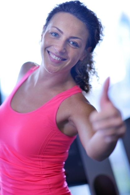 Sport-, Fitness-, Lebensstil-, Technologie- und Personenkonzept - lächelnde Frau, die auf Laufband im Fitnessstudio trainiert