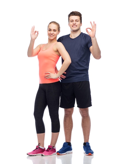 Sport, Fitness, Lebensstil und Menschenkonzept - glücklicher sportlicher Mann und Frau