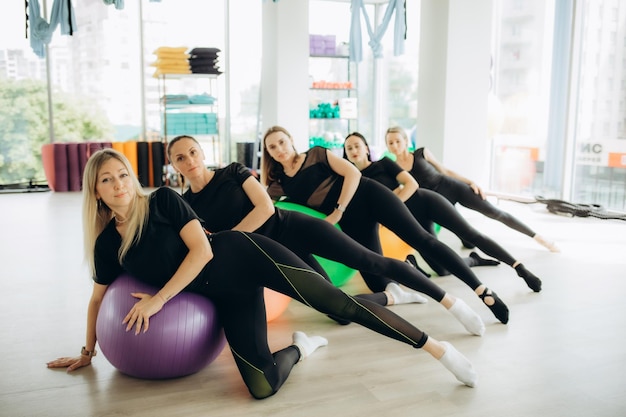 Foto sport-fitness-training und lifestyle-konzept gruppe lächelnder frauen mit trainingsbällen im fitnessstudio hochwertiges foto