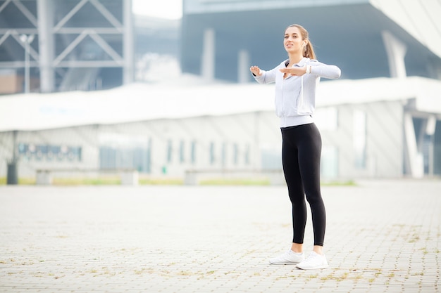 Sport im Freien, hörende Musik der Frau am Telefon beim draußen trainieren