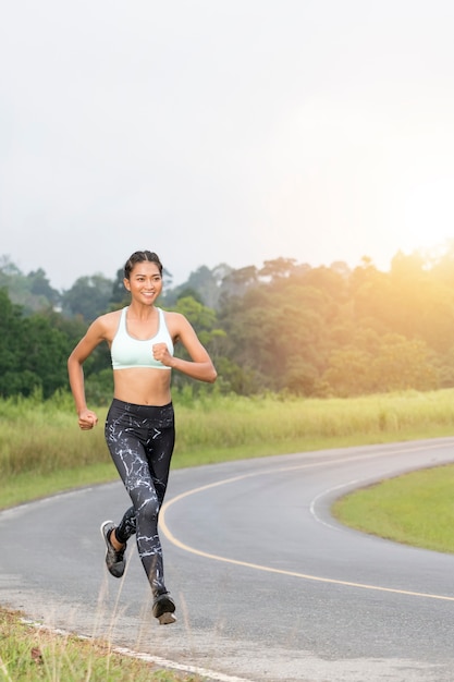 Sport Mädchen Joggen im Dschungel Trail mit Sonnenaufgang oder Sonnenuntergang.