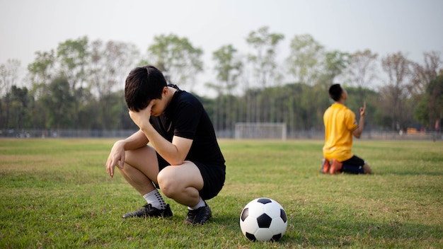 Sport und Erholung ein Moment des Sieges und der Niederlage zweier Spieler nach dem Fußballspiel.