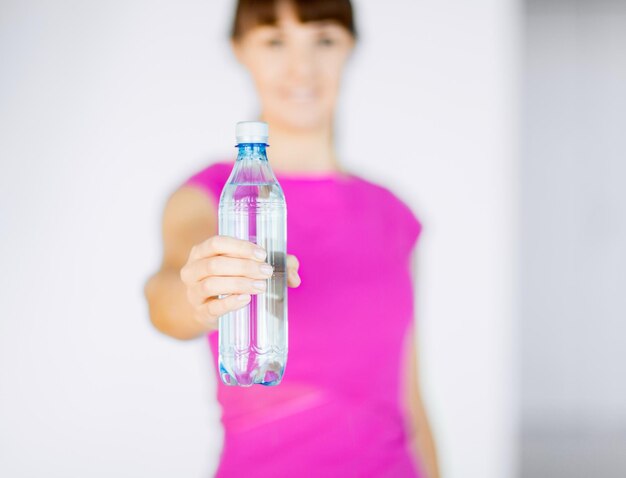 Sport- und Ernährungskonzept - sportliche Frau mit Flasche Wasser