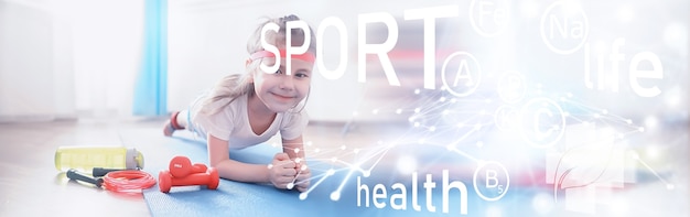 Sport und gesunder Lebensstil. Kind, das zu Hause Sport treibt. Yogamatte Hantel und Springseil. Sporthintergrund mit Heimübungskonzept.