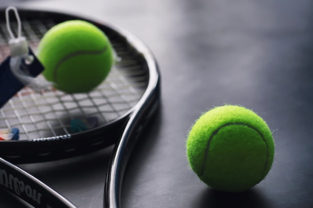 Sport und gesunder Lebensstil. Tennis. Gelber Ball für Tennis und Schläger auf dem Tisch. Sporthintergrund mit Tenniskonzept.