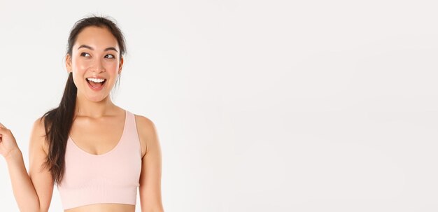 Sport, Wohlbefinden und aktives Lifestyle-Konzept Fröhlich lächelnde asiatische Sportlerin im Sportsbra-Look