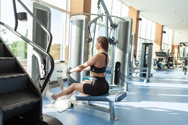 Sport Woman Zugkabelruder, Zugkabel des Rudergerätetrainings im Fitnessstudio