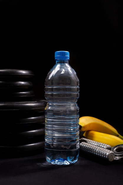 Sportausrüstung mit wasserflasche auf einem schwarzen