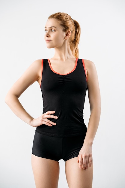 Sportbekleidung für Frauen Kleidung für das Branding Fitness-Outfit Aktiver Lebensstil Vorderansicht der Sportlerin mit schlankem Körper in schwarzen Tank-Top-Shorts mit Logo-Mockup isoliert auf neutral