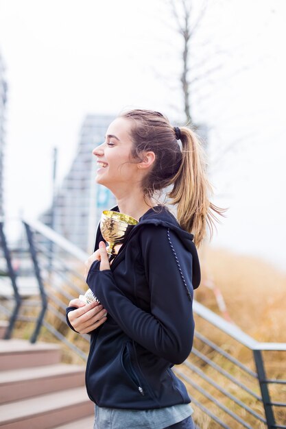 Sportfrau, die eine Trophäe hält