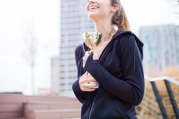 Sportfrau, die eine Trophäe hält