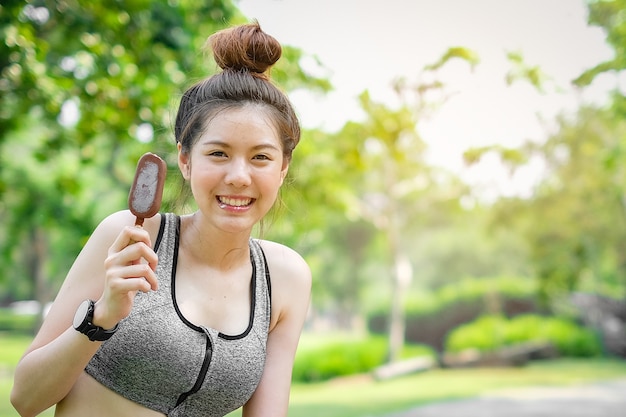 Sportfrau, die Eiscreme in den Händen auf Sommer hält