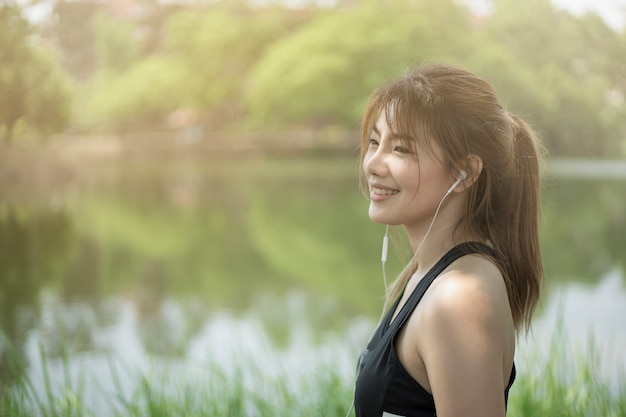 Sportfrau, die Musik mit Kopfhörern im Park hört