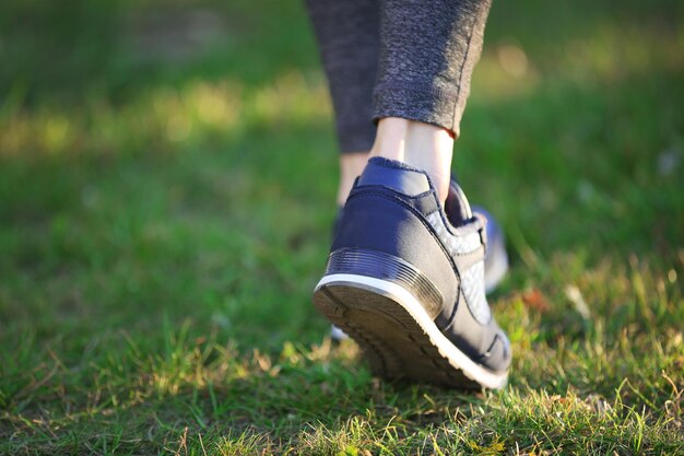 Sportfrauenbeine in den Turnschuhen im Freien