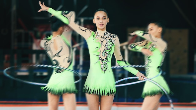 Sportgymnastik und Frau, die mit einem Hula-Hoop in einem Studio mit einer sich drehenden Unschärfebewegung auftreten Fitness-Turnerin und Sportlerin, die Beweglichkeitsfähigkeiten oder Flexibilität für eine Routine in einem Fitnessstudio üben